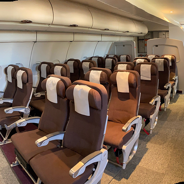 Seating area of Airplane Cabin mock-up, including life jackets, seatbelts, and overhead bins at the  Training Facilities.